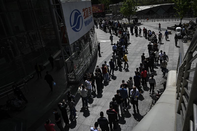 People line up to be tested for Covid-19 coronavirus outside a supermarket in Beijing on April 26, 2022, the day the Chinese capital launched mass coronavirus testing for nearly all its 21 million people. Credit: AFP