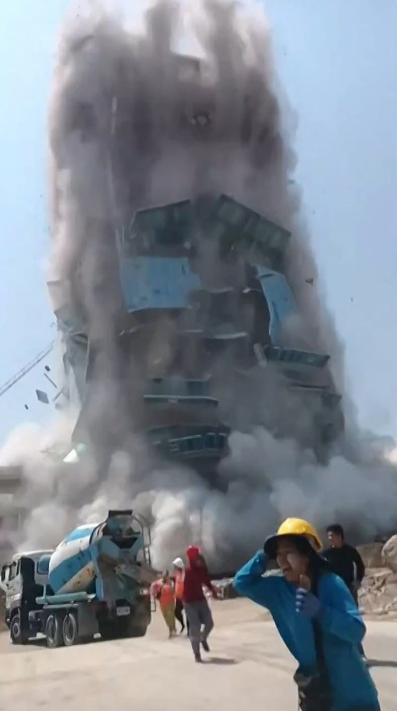 Workers run from a building as it collapses at a construction site in Bangkok, during an earthquake in central Myanmar.
