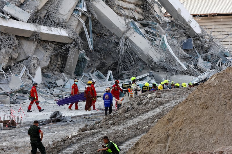 Rescue personnel work near a building that collapsed after a strong earthquake struck central Myanmar on Friday, earthquake monitoring services said, which affected Bangkok as well with people pouring out of buildings in the Thai capital in panic after the tremors, in Bangkok, Thailand, March 28, 2025.