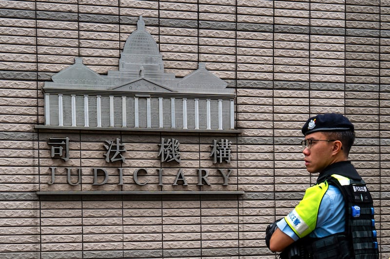 A police officer stands outside the West Kowloon court where jailed Hong Kong media mogul Jimmy Lai's national security trial is taking place in Hong Kong on Aug. 28, 2025.