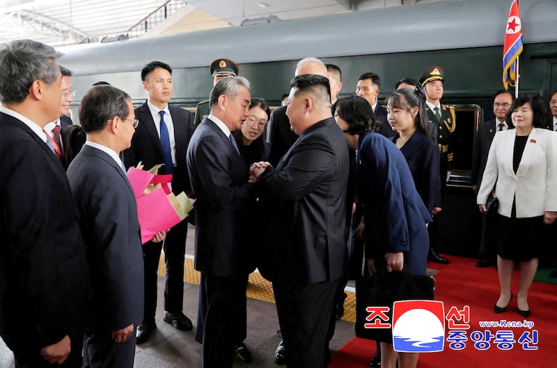 This image released by the North Korean government shows North Korean leader Kim Jong Un greeted by Chinese Foreign Minister Wang Yi as he arrives in Beijing on Sept. 2, 2025. Kim's daughter Ju Ae stands fourth from right.