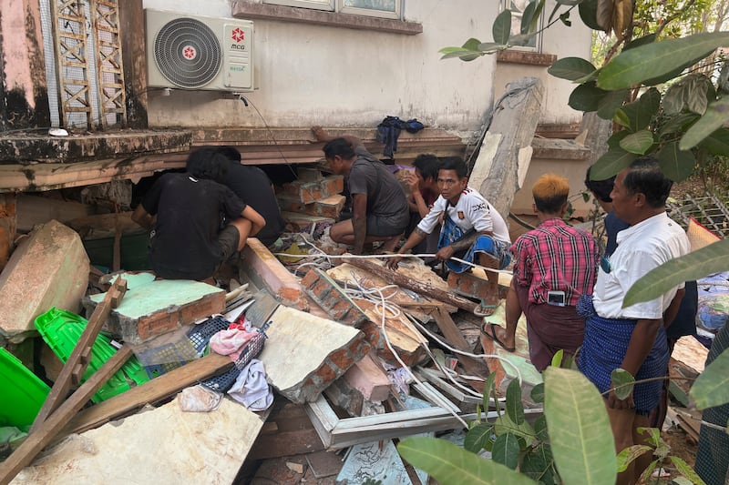 Volunteers look for survivors at a damaged building after an earthquake in Naypyidaw, Myanmar.