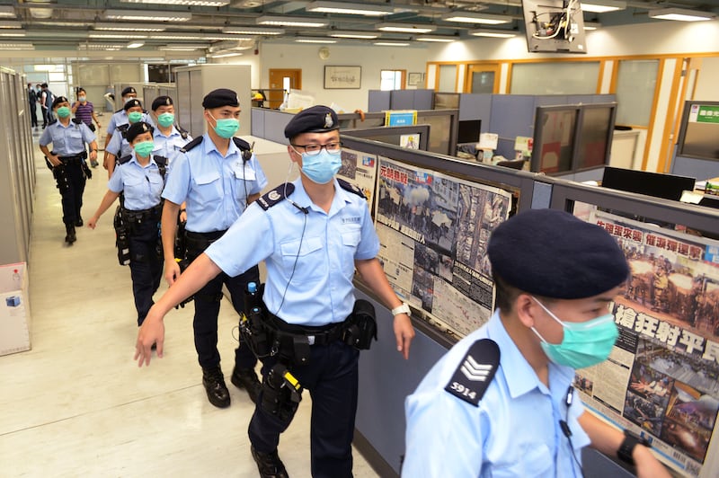 Hong Kong police officers search the office of Apple Daily newspaper on Aug. 10, 2020.
