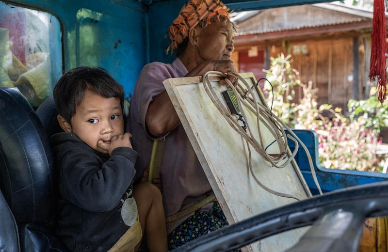 A child and her grandmother sit in a tractor to flee from Phuk Khe village as Myanmar junta attacks Moe Bye to Peinnegon main road in Shan state, Myanmar, Oct. 30, 2024.